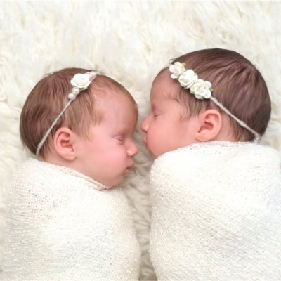 newborn twins wrapped in a white blanket